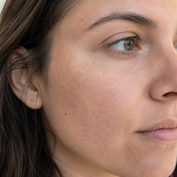 Close-up of a woman's face with visible skin texture and expression.